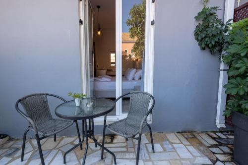 a glass table and chairs on a patio at Kate-Mari studios in Skala