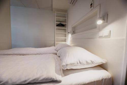 1 Schlafzimmer mit 2 Betten und weißen Kissen in der Unterkunft Appartementen Renesse in Renesse