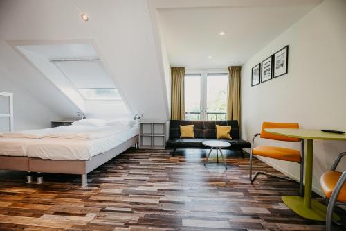 a hotel room with a bed and a couch at Appartementen Renesse in Renesse