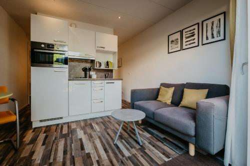 ein kleines Wohnzimmer mit einem Sofa und einem Tisch in der Unterkunft Appartementen Renesse in Renesse
