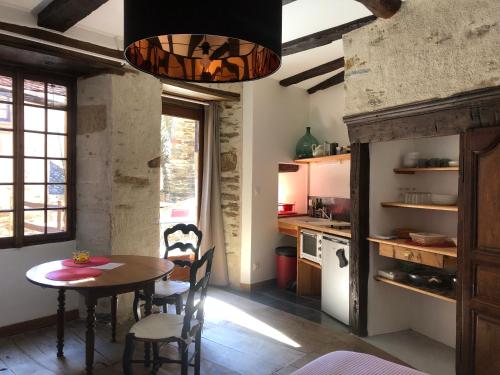 kuchnia i jadalnia ze stołem i krzesłami w obiekcie LA CONQUISE w mieście Conques-en-Rouergue
