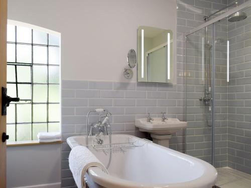 a white bathroom with a tub and a sink at The Pump House in Kiddemore Green