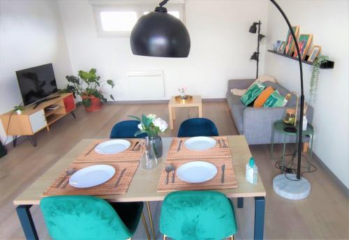 une table à manger et des chaises dans un salon dans l'établissement CHIC 2CHAMBRES,70m²+balcon+parking+WIFI, à Nantes