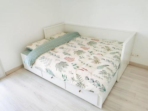 a bed in a room with a white wall at CHIC 2CHAMBRES,70m²+balcon+parking+WIFI in Nantes