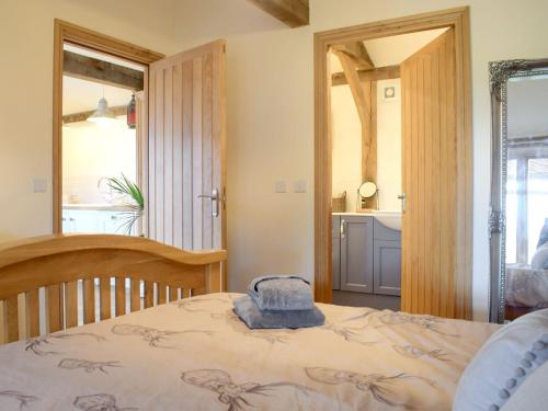 1 dormitorio con 1 cama con sombrero en Rushmoor Lodge en Admaston