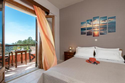a bedroom with a bed and a balcony at Sunset and Sunrise Apartments "Goulakia" by Corfuescapes in Karousádes