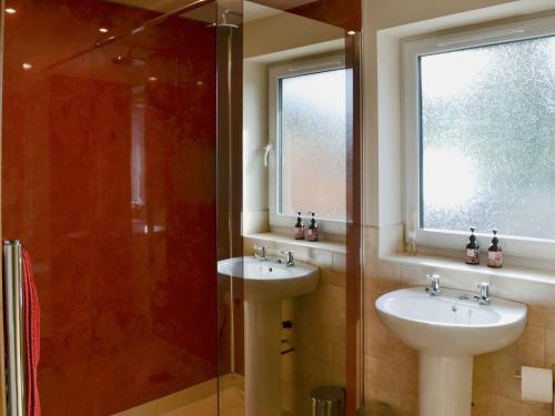 a bathroom with two sinks and a glass shower at The Old Rectory Lodge in Great Carlton