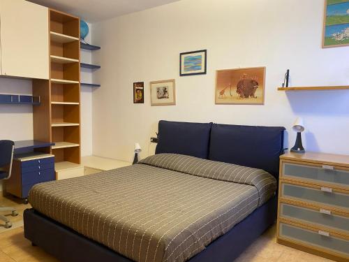馬里納－迪格羅塞托的住宿－Ville sul Mare，一间卧室配有一张床、一张桌子和书架