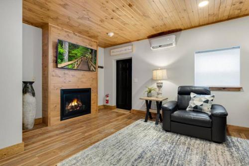 a living room with a chair and a fireplace at Hickory Suite - Main Street Lodge in Berlin in Berlin