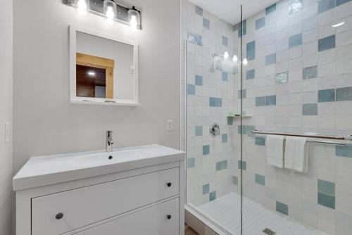 a white bathroom with a sink and a shower at Hickory Suite - Main Street Lodge in Berlin in Berlin