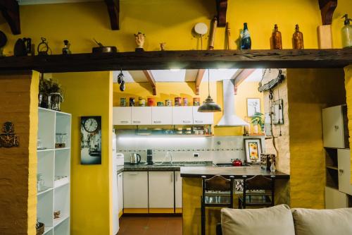 a kitchen with yellow walls and white cabinets at Casa céntrica que cumple todas tus necesidades in Colonia del Sacramento