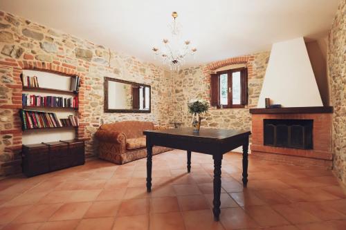 a living room with a table and a fireplace at Casa Il giuggiolo in Giuncarico