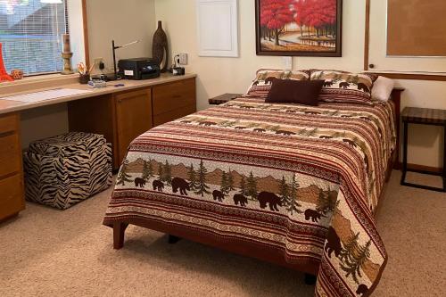 Un dormitorio con una cama con una manta. en Cozy one bedroom with privacy - Community beach access en Sandpoint