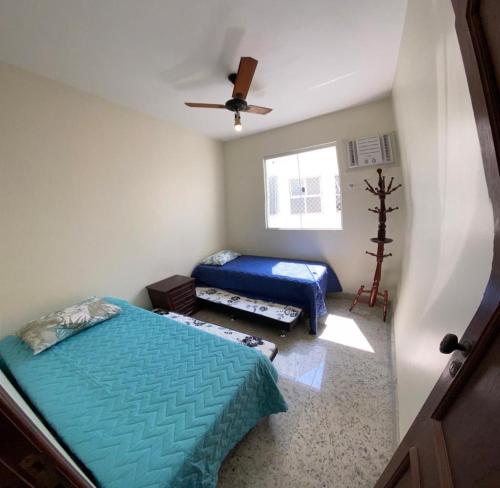 een slaapkamer met 2 bedden en een plafondventilator bij Apartamento - CARIBE BRASILEIRO - Praia do Forte - De frente para o mar in Cabo Frio