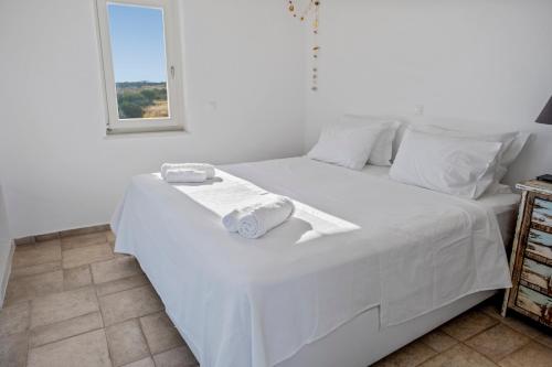 a white bed with two towels on top of it at Studio with Seaview at Faragas in Angairiá