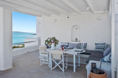 a white living room with a table and a couch at Studio with Seaview at Faragas in Angairiá
