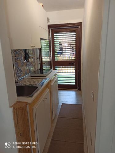 a kitchen with a sink and a window at Casa Perla Rei - 50 meters from the beach in Costa Rei