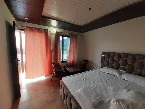a bedroom with a large bed and a large window at Lake Haven Resort, Sari, Chopta in Sari