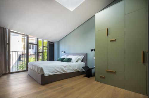 sypialnia z łóżkiem i dużym oknem w obiekcie Heart Milan Apartments Porta Romana w Mediolanie