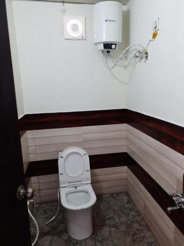 a bathroom with a white toilet in a room at Lake Haven Resort, Sari, Chopta in Sari