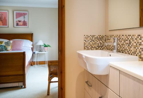 a bathroom with a sink and a bed at Croft House Sleeps 14 ꕤ Country Views nr Salisbury in Salisbury