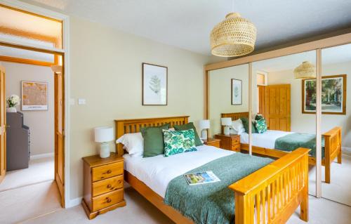 a bedroom with two beds and a mirror at Croft House Sleeps 14 ꕤ Country Views nr Salisbury in Salisbury