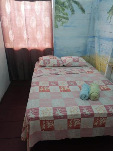 a bed with two towels on top of it at El Jaguar in Bocas del Toro