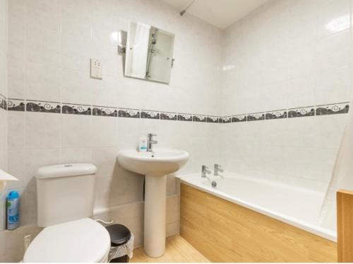 La salle de bains est pourvue de toilettes, d'un lavabo et d'une baignoire. dans l'établissement Quayside, à Wroxham