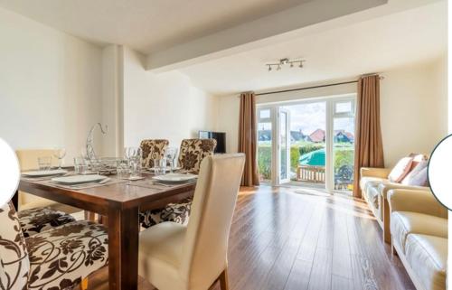 a dining room with a table and chairs and a couch at Quayside in Wroxham