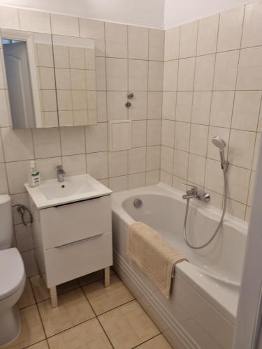 a bathroom with a tub and a sink and a toilet at Apartament na Żeromskiego in Gdynia