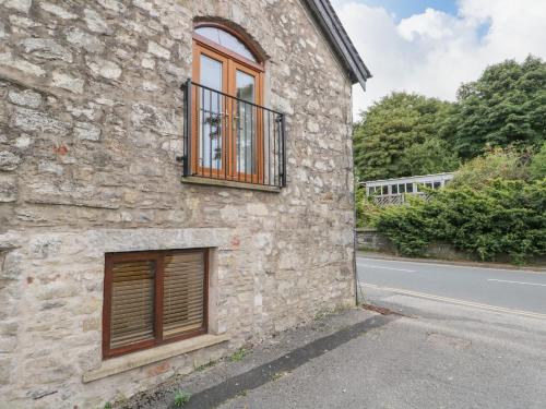 a stone building with a window on the side of a road at Coach House in Carnforth