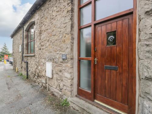 uma porta de madeira ao lado de um edifício de tijolos em Coach House em Carnforth