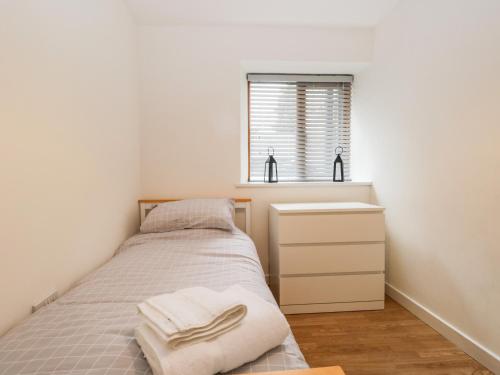a small bedroom with a bed and a sink at Coach House in Carnforth