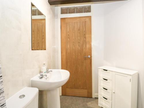uma casa de banho branca com um lavatório e um WC em Coach House em Carnforth