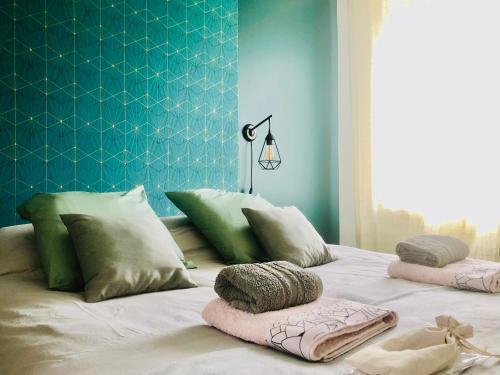 uma cama com almofadas com uma parede azul em Au petit canal de Bavilliers em Bavilliers