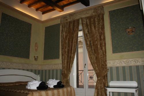a bedroom with a bed and a window with curtains at Upper View Suite in Rome