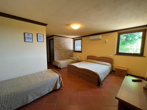 a hotel room with two beds and a window at Alloggio Agrituristico Ronchi Di Fornalis in Cividale del Friuli