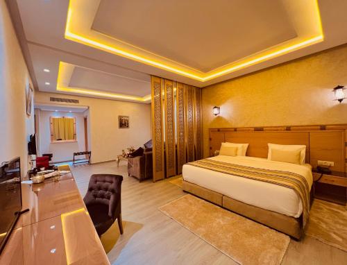 メクネスにあるZ Hotel Meknesのベッドとリビングルームが備わるホテルルームです。