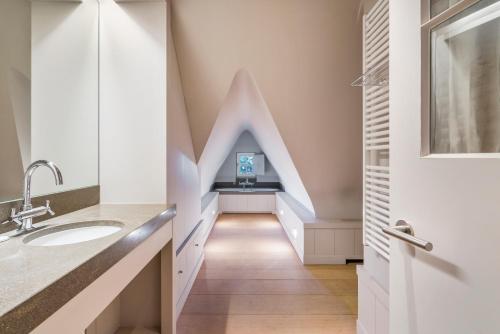 een badkamer met een trap met een wastafel en een tv bij Luxe duplex villa8p in cottagestijl met wellness in Knokke-Heist
