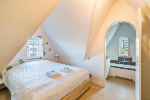 ein Schlafzimmer mit einem großen weißen Bett und einem Waschbecken in der Unterkunft Luxe duplex villa8p in cottagestijl met wellness in Knokke-Heist