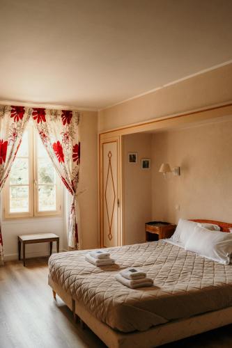a bedroom with a large bed and a window at Hôtel Le Cro-Magnon in Les Eyzies-de-Tayac