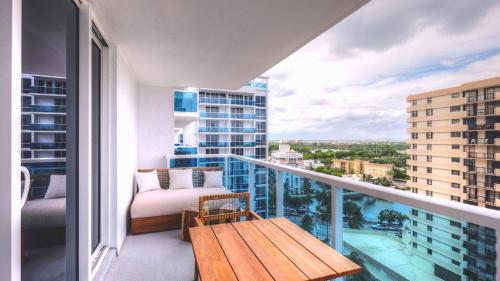 een balkon met een houten tafel en uitzicht op de stad bij Oceanview Private Condo at 1 Hotel & Homes -1211 in Miami Beach