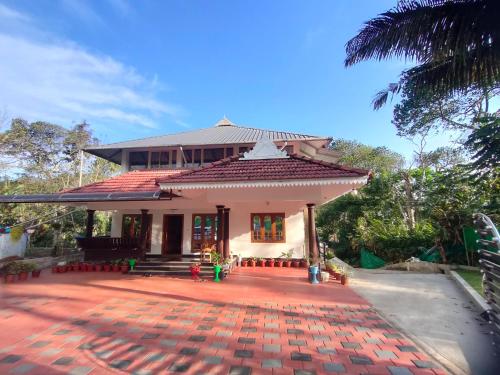 a house with a red brick walkway in front of it at Villoonnickal Homestay in Munnar