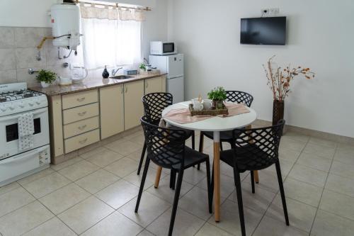 Una cocina con una mesa y sillas en una cocina. en Moana Alojamientos, en Junín