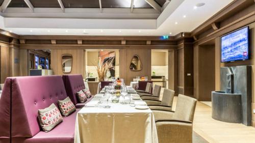 a dining room with a long table and purple chairs at Hotel Indigo Rome - St. George by IHG in Rome