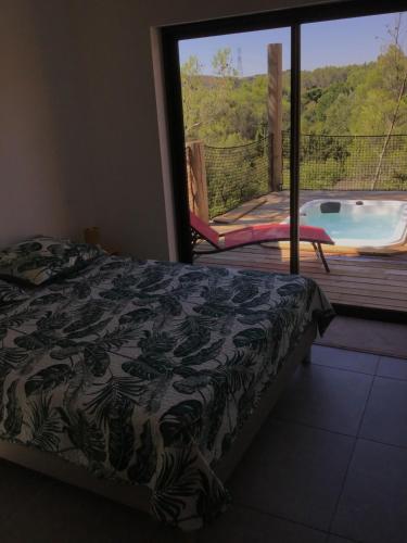 1 dormitorio con cama y vistas a la piscina en Avignon : Le Mas Cott, le paradis dans la nature, en Aramon