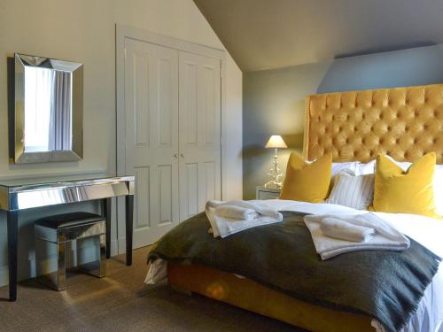 a bedroom with a large bed and a desk at Darroch View in Ballater