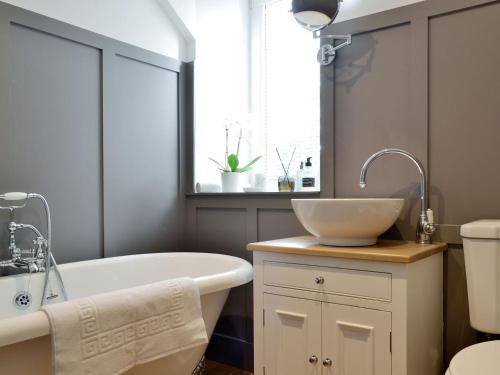 a bathroom with a tub and a sink and a window at Darroch View in Ballater