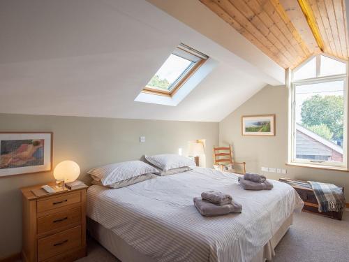 a bedroom with a large bed with two towels on it at Top House in Forden