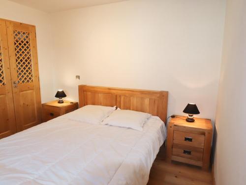 ein Schlafzimmer mit einem Bett und zwei Nachttischen mit Lampen in der Unterkunft Appartement Samoëns, 2 pièces, 5 personnes - FR-1-624-105 in Samoëns